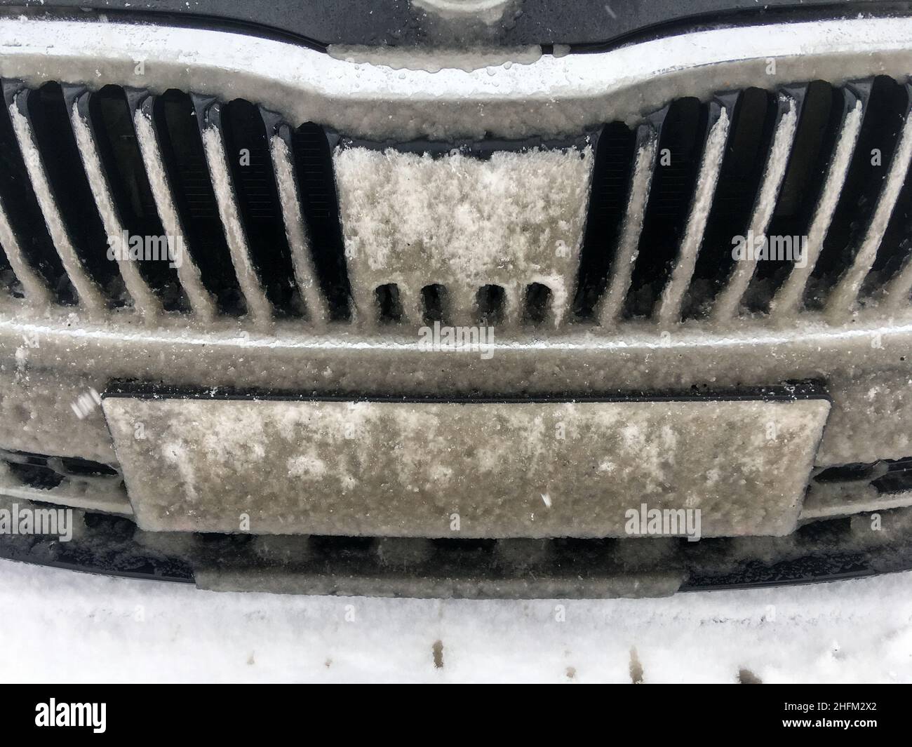 Il dettaglio della griglia del radiatore dell'auto completamente coperto da fiaccate. Il sensore radar è cieco. Problema per i sistemi moderni causato dalle condizioni atmosferiche. Foto Stock