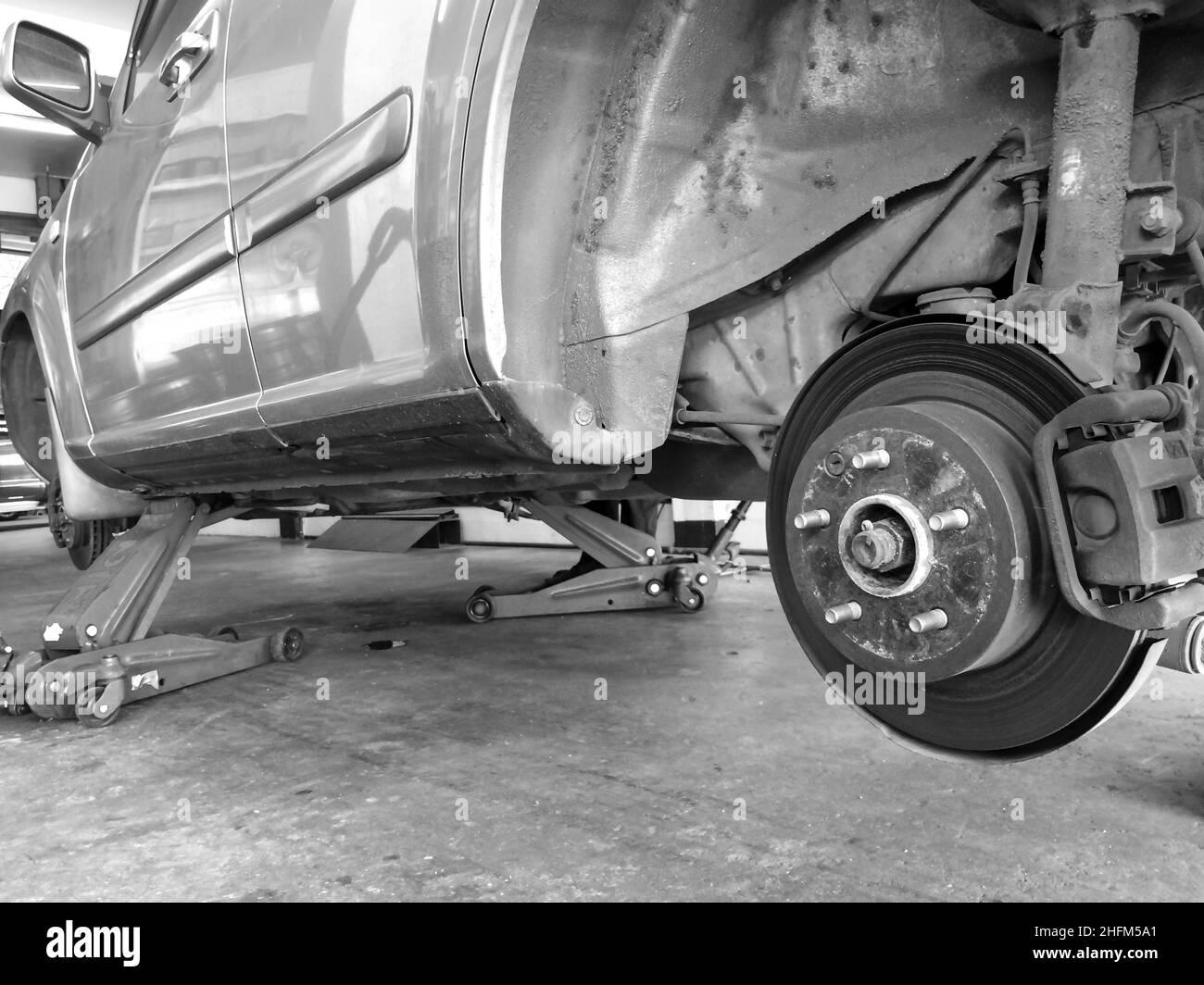 Complessivo mozzo ruota nel processo di sostituzione ruota SUV in servizio in un garage. Concentrarsi sul mozzo ruota. Foto Stock