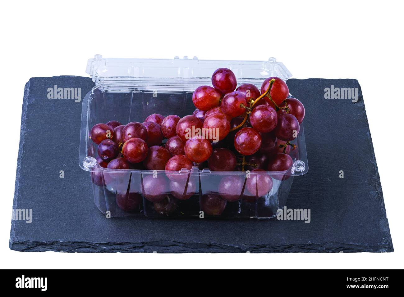 Vista ravvicinata di un mazzo di uve confezionate in scatola di plastica isolata su sfondo bianco. Foto Stock