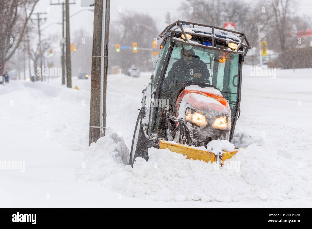 Un dipendente della città gestisce un dispositivo per lo sgombero della neve sul marciapiede di Victoria Park Avenue durante una tempesta invernale di neve a Toronto, Canada Foto Stock