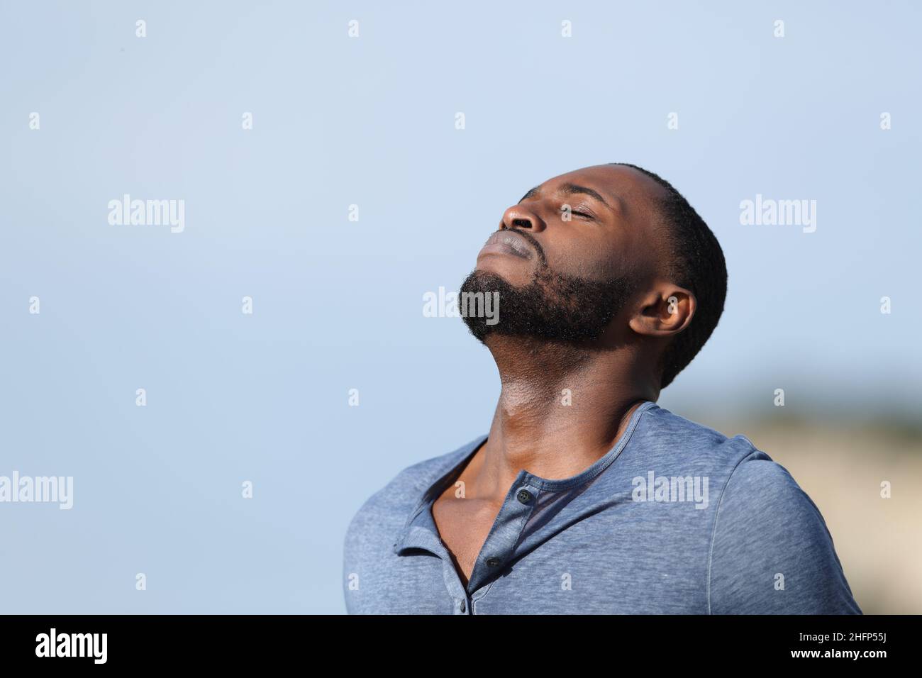 Uomo rilassato con pelle nera respirando aria fresca all'esterno della montagna Foto Stock