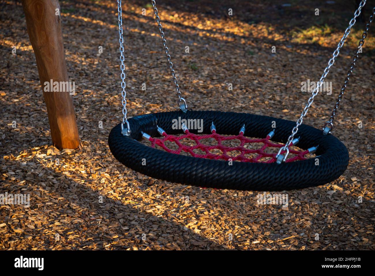 Oscillazione a catena con fili di tessuto imbottiti in un moderno parco giochi per bambini Foto Stock