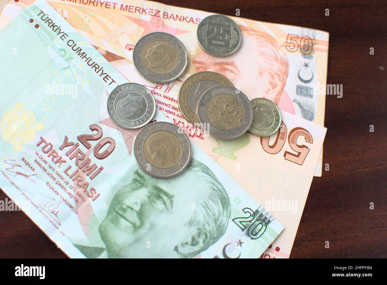 Alcune banconote e monete turche su sfondo marrone. Alcune liras turche per pagare le bollette su un tavolo marrone. Foto Stock