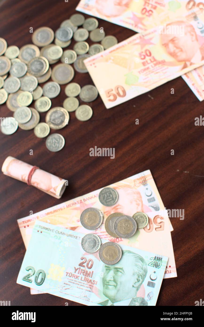 Alcune banconote e monete turche su sfondo marrone. Alcune liras turche per pagare le bollette su un tavolo marrone. Foto Stock