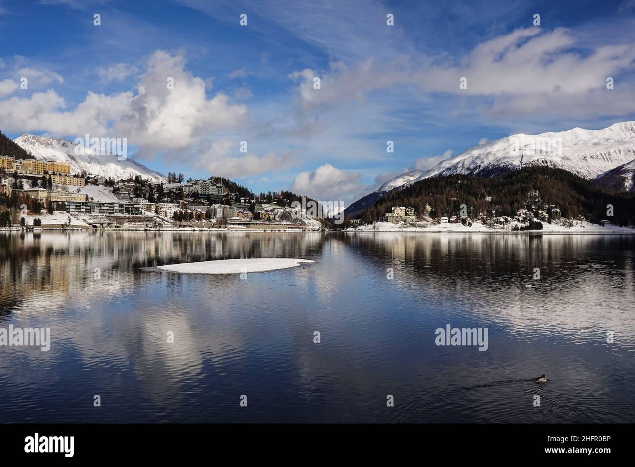 Riflesso drammatico del famoso villaggio di Saint Moritz nel lago in una giornata invernale soleggiata nel Cantone Graubunden, nelle alpi della Svizzera Foto Stock