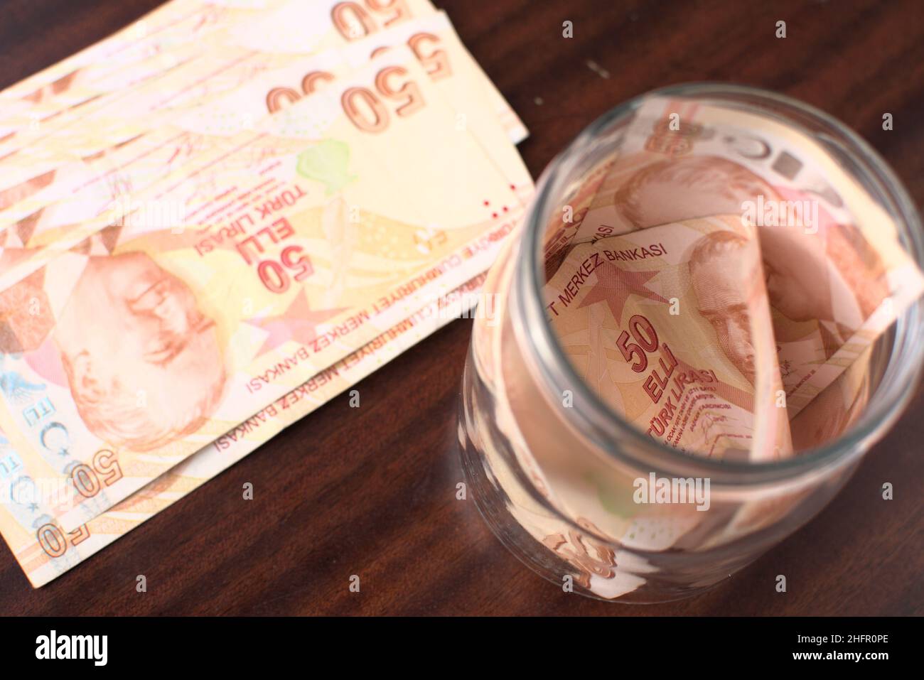 Circa 50 liras turche per salvare in un vaso su uno sfondo marrone. Foto Stock