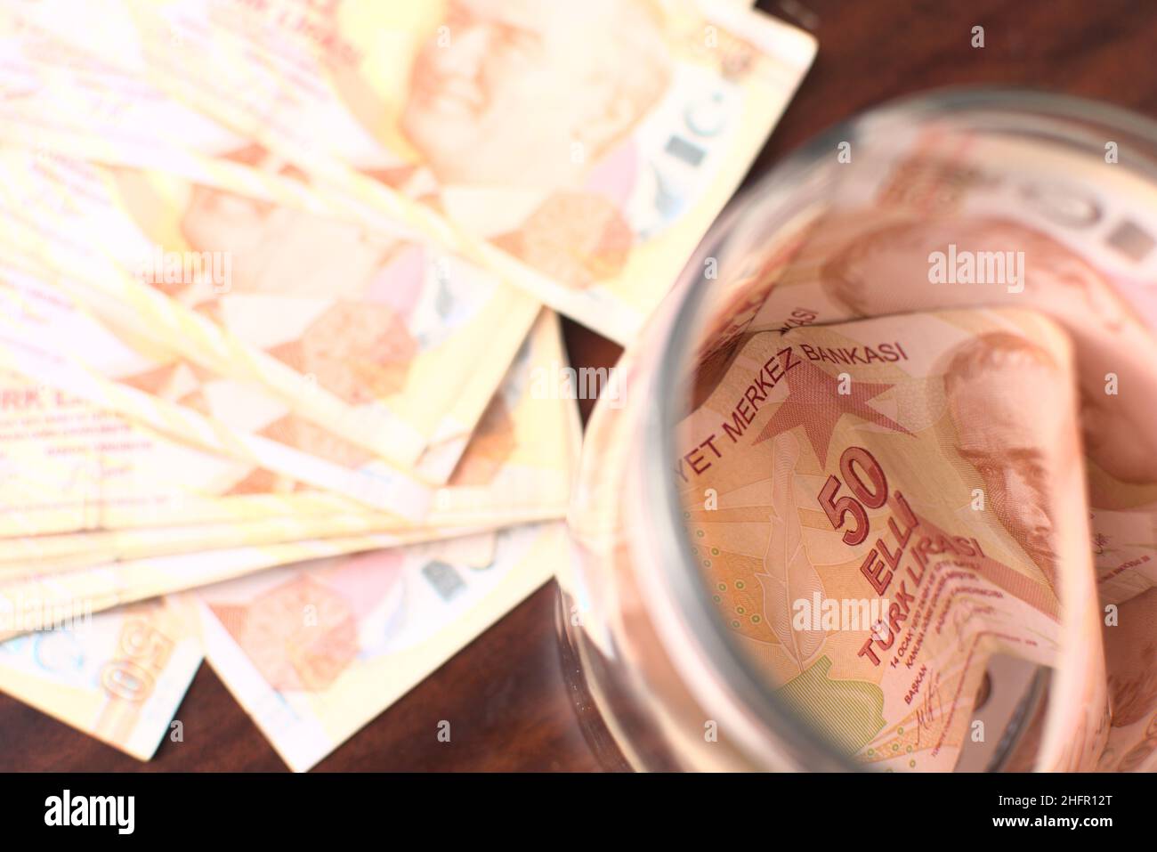 Circa 50 liras turche per salvare in un vaso su uno sfondo marrone. Foto Stock