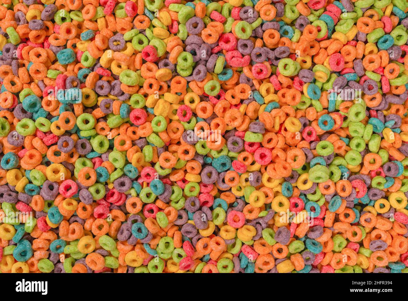 Dolci fiocchi multicolore, anelli di cereali come sfondo. Foto Stock