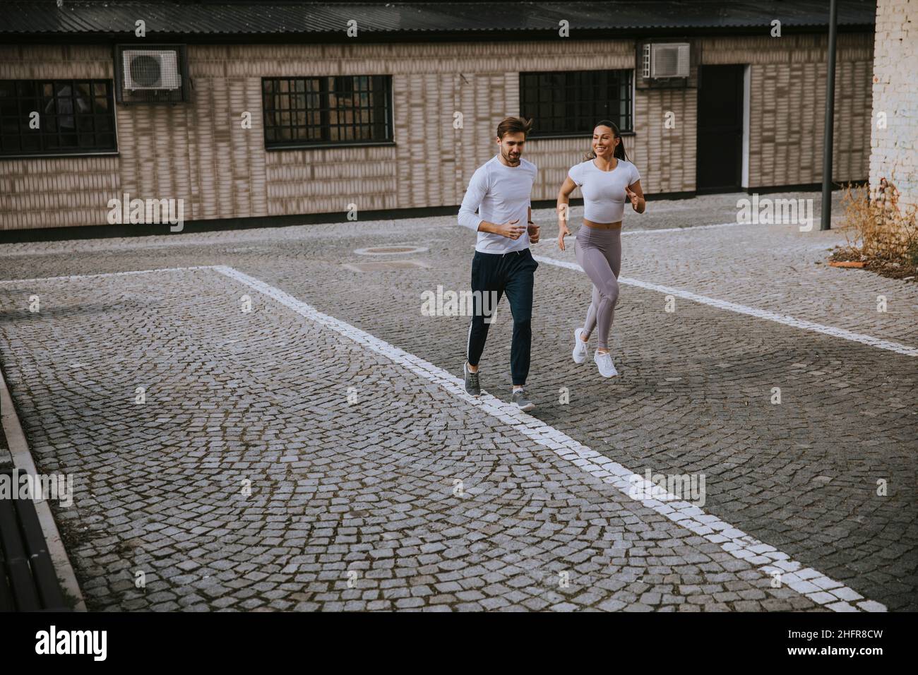 Bella giovane coppia di fitness che corre in zona urbana Foto Stock