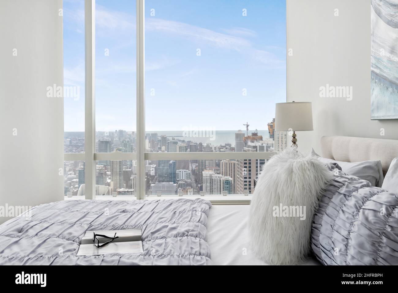 Camera Luxury Penthouse con vista sulla città e sul lago dalle finestre da pavimento a soffitto. Elegante design interno della camera da letto. Moderno e contemporaneo Foto Stock