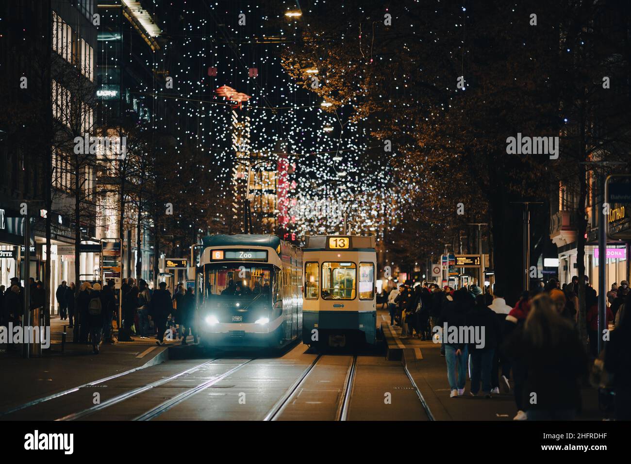 Zurigo, Svizzera - Dicembre 12 2021: Un tram percorre la Bahnhofstrasse, il viale principale del centro di Zurigo con decorazioni natalizie Foto Stock