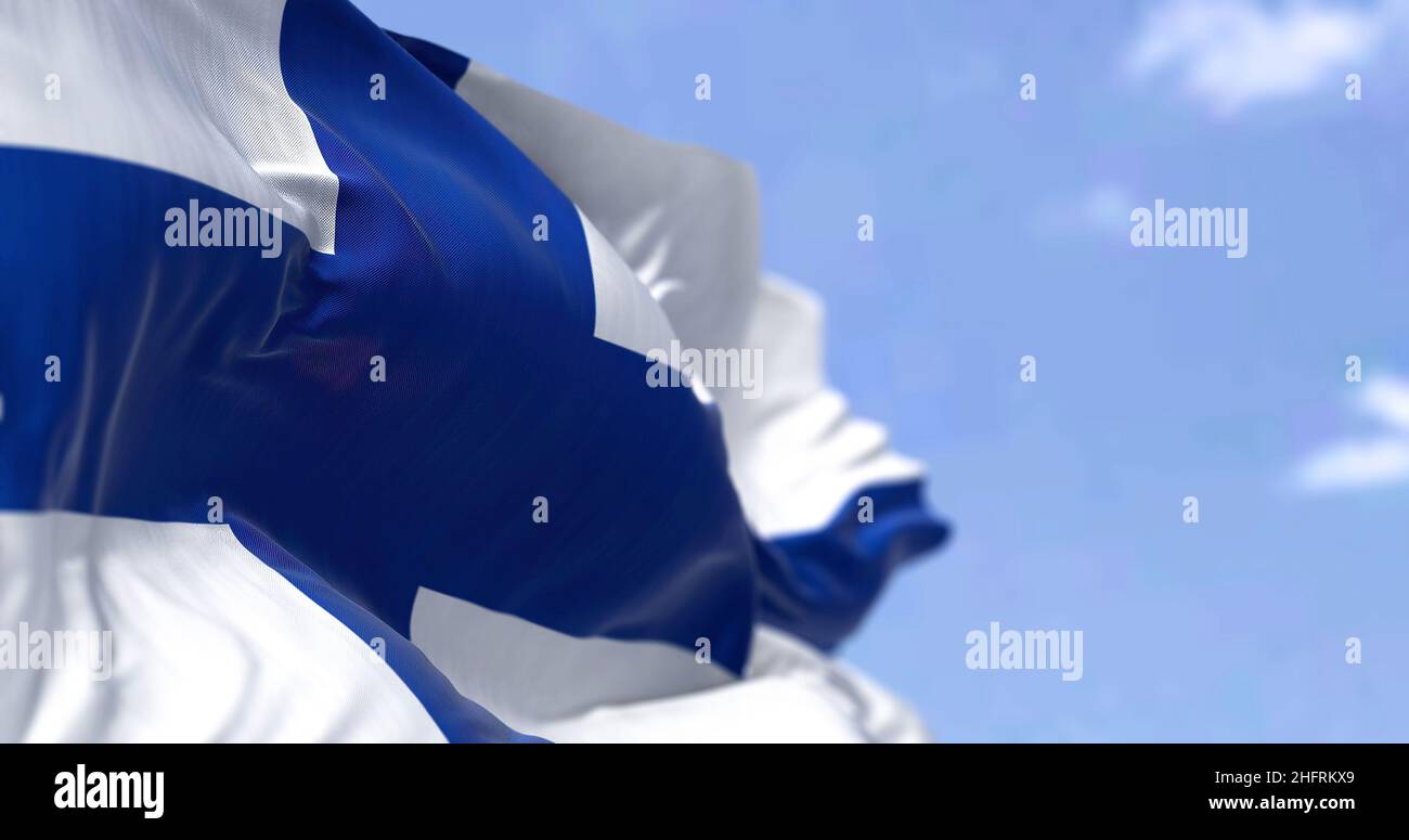 Dettaglio della bandiera nazionale della Finlandia che sventola al vento in una giornata limpida. Democrazia e politica. Paese del Nord Europa. Messa a fuoco selettiva. Foto Stock