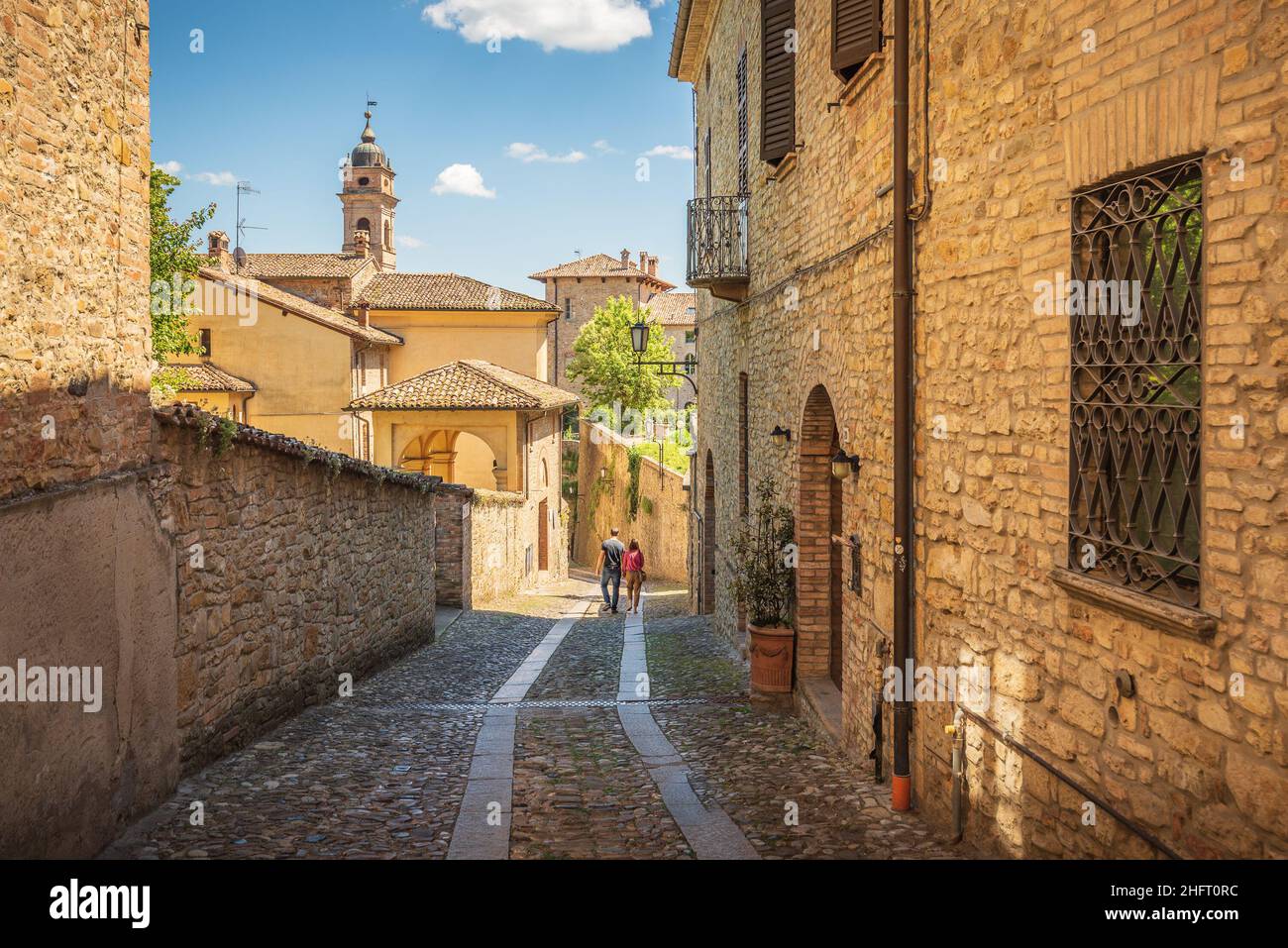 Coppia a piedi un piccolo vicolo a Castell'Arquato in una giornata di sole, Piacenza, Italia Foto Stock