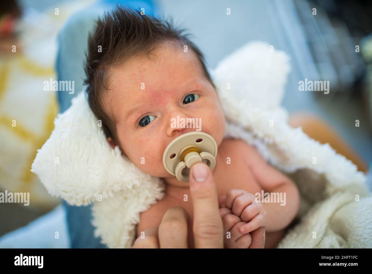 Dettaglio del genitore che tiene il succhietto nella bocca del neonato. Foto Stock