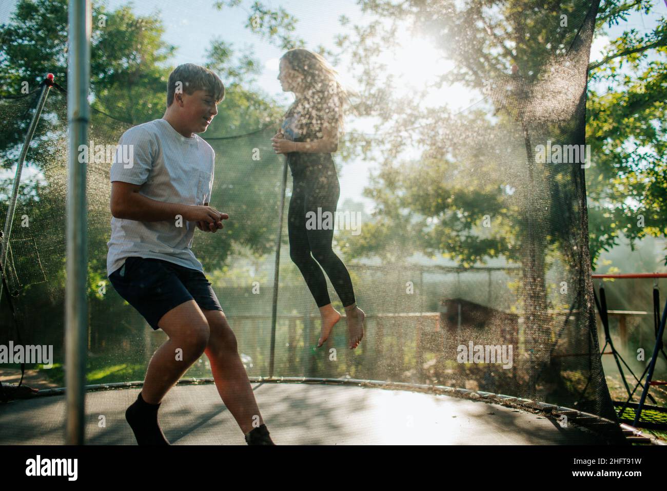 Due adolescenti che saltano sul trampolino all'esterno Foto Stock