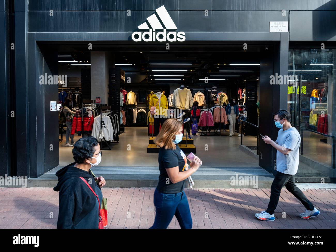 I pedoni camminano accanto al negozio Adidas di marca tedesca di  abbigliamento sportivo multinazionale a Hong Kong. (Foto di Budrul Chukrut  / SOPA Images/Sipa USA Foto stock - Alamy