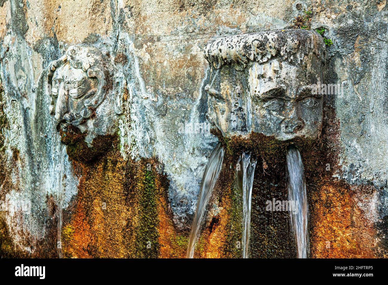 Gargoyles a forma di teste che gettano acqua in una fontana medievale a Pietranico. Pietranico, provincia di l'Aquila, Abruzzo, Italia, Europa Foto Stock