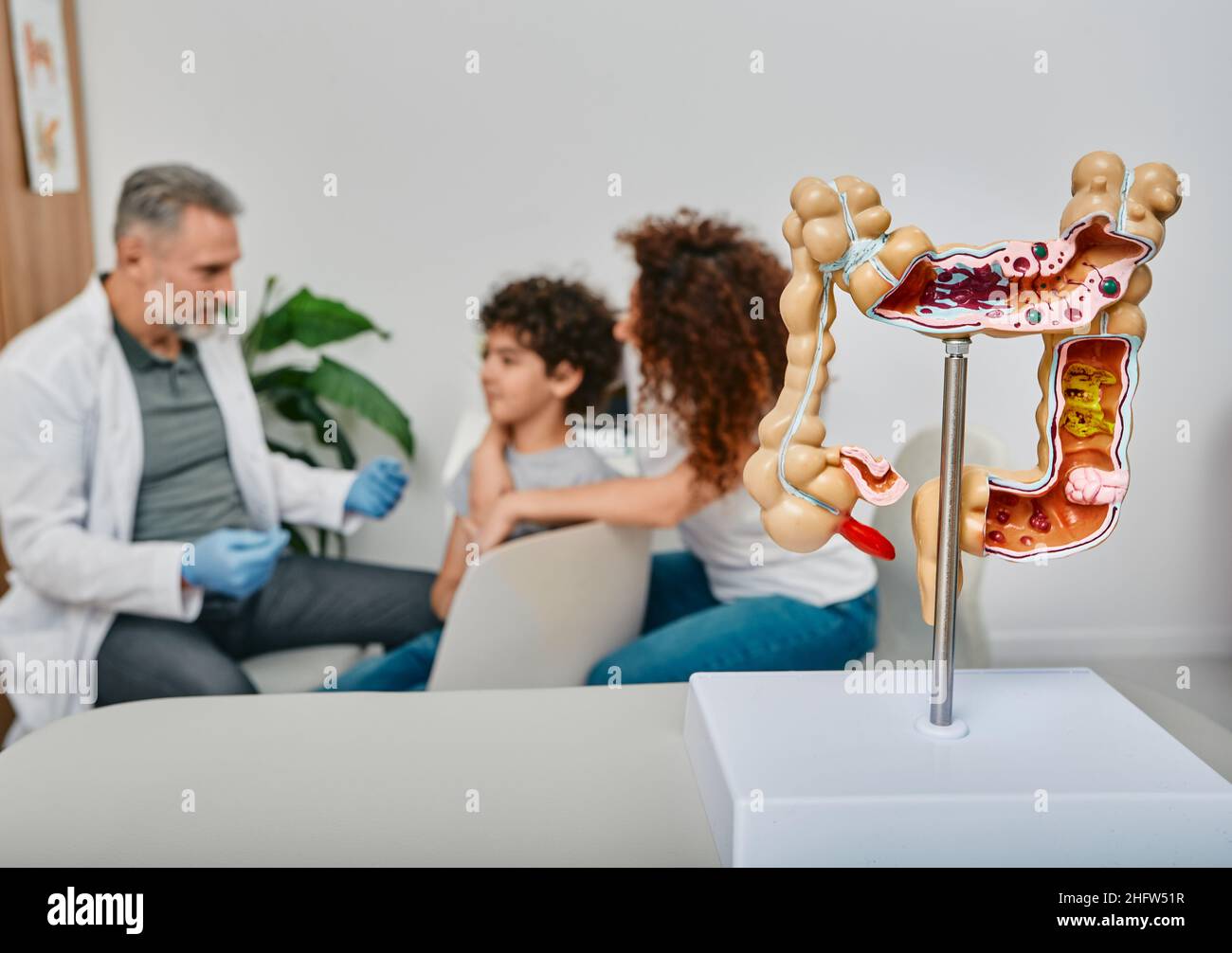 Consultazione gastroenterologo per il paziente bambino. Modello anatomico dell'intestino sul tavolo medico in primo piano Foto Stock