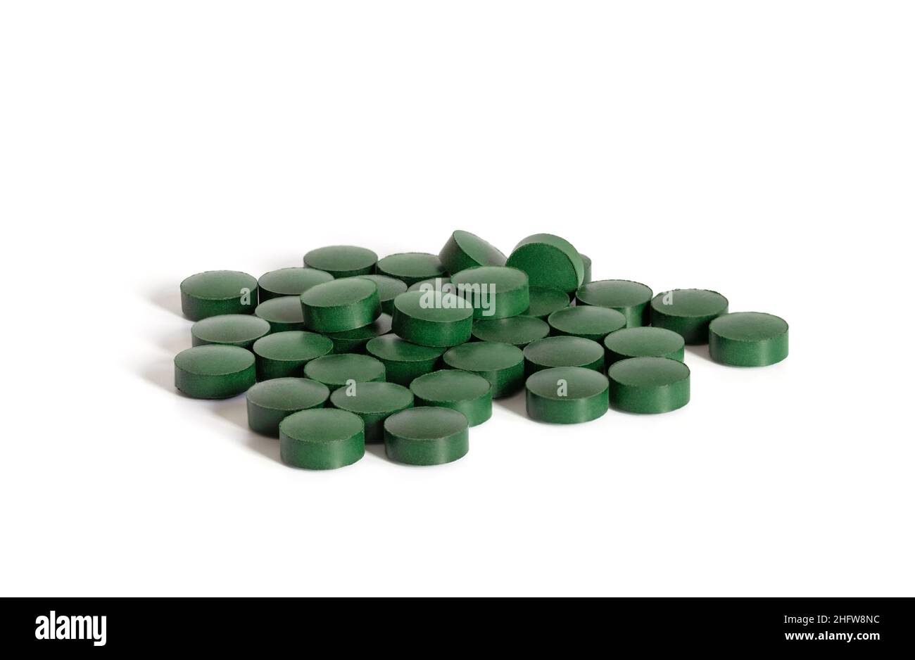 Spirulina pillole verdi isolato su uno sfondo bianco primo piano. Compresse di clorella. Superfood e supplemento alimentare. Foto Stock