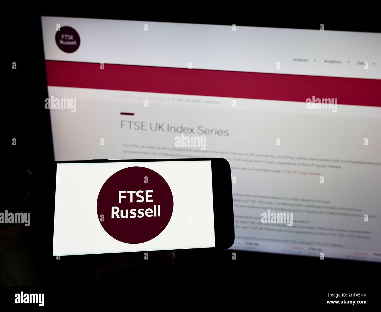 Persona che tiene uno smartphone con il logo della società britannica FTSE Russell (LSEG) sullo schermo di fronte al sito Web. Mettere a fuoco sul display del telefono. Foto Stock