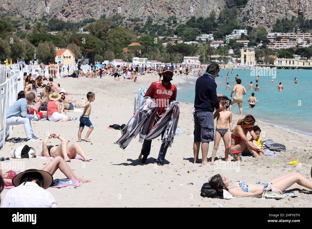 Foto Alberto lo Bianco/LaPresse 16-05-2021 Mondello (PA) Cronaca A Palermo nell’ultima domenica di zona arancione si respira già aria d’estate. Scaduta l’ordinanza del sindaco Leoluca Orlando che visita l’accesso ai litorali nel weekend, lotti palermitani hanno così appropriato del bel tempo per i recarsi in spiaggia a Mondello. Nella foto: spunta pure il vucumprà Foto Alberto lo Bianco/LaPresse 16 maggio 2021 Mondello (PA) News ultimo giorno della zona arancione in Sicilia. A Mondello, 30 gradi e la spiaggia è piena di persone. Foto Stock