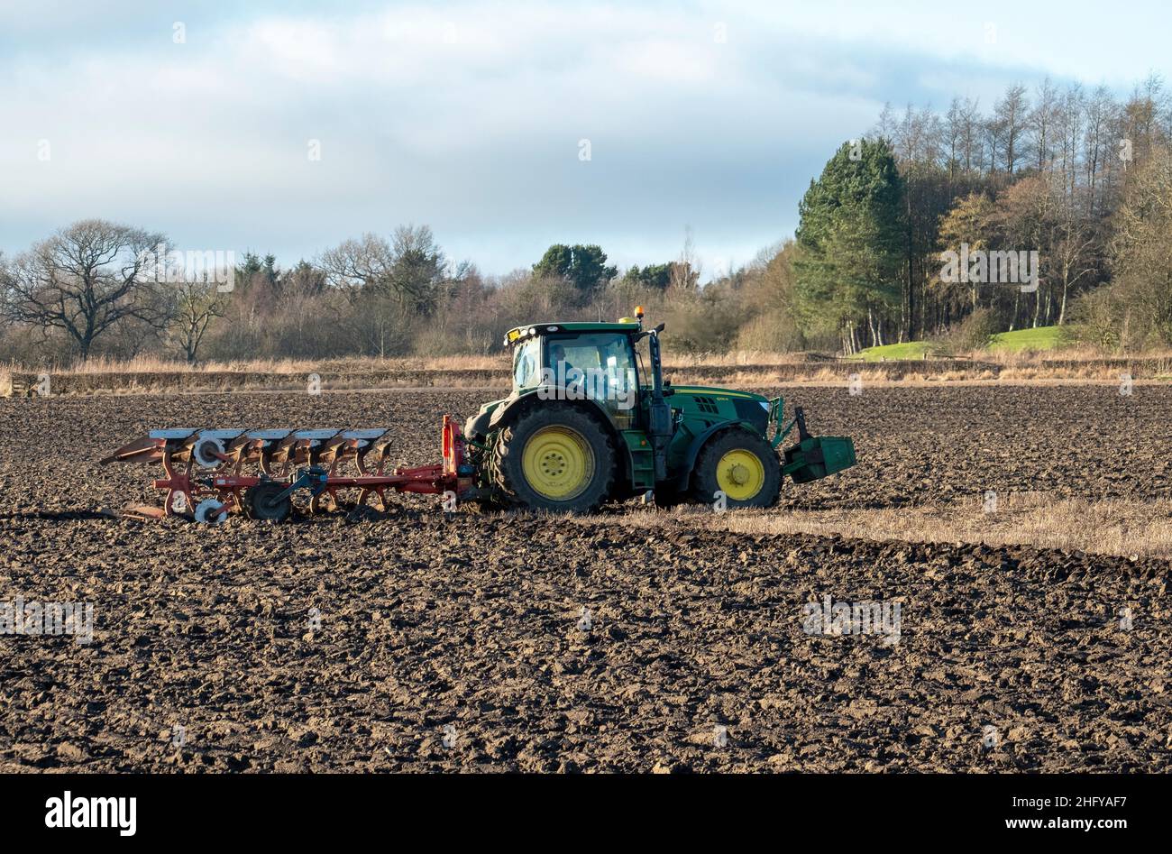 Trattore e aratro per la preparazione del terreno in aree lontane a West Lothian, Scozia. Foto Stock
