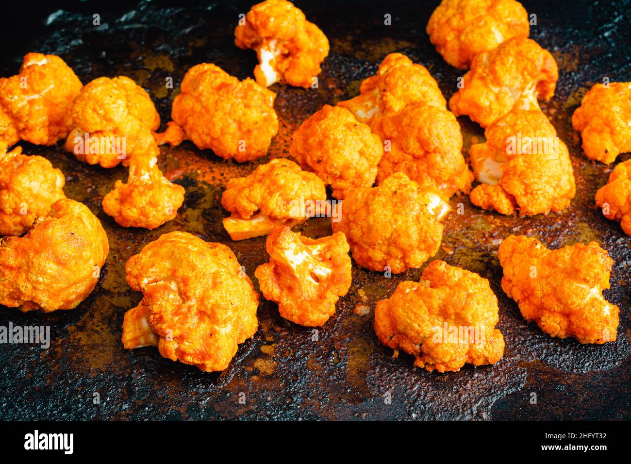 Fiori di cavolfiore conditi con salsa calda: Cavolfiore fresco condito con salsa calda su una teglia Foto Stock