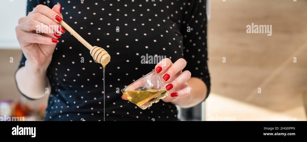 Primo piano a portata di mano sconosciuta donna caucasica che tiene e versando spazio copia miele Foto Stock