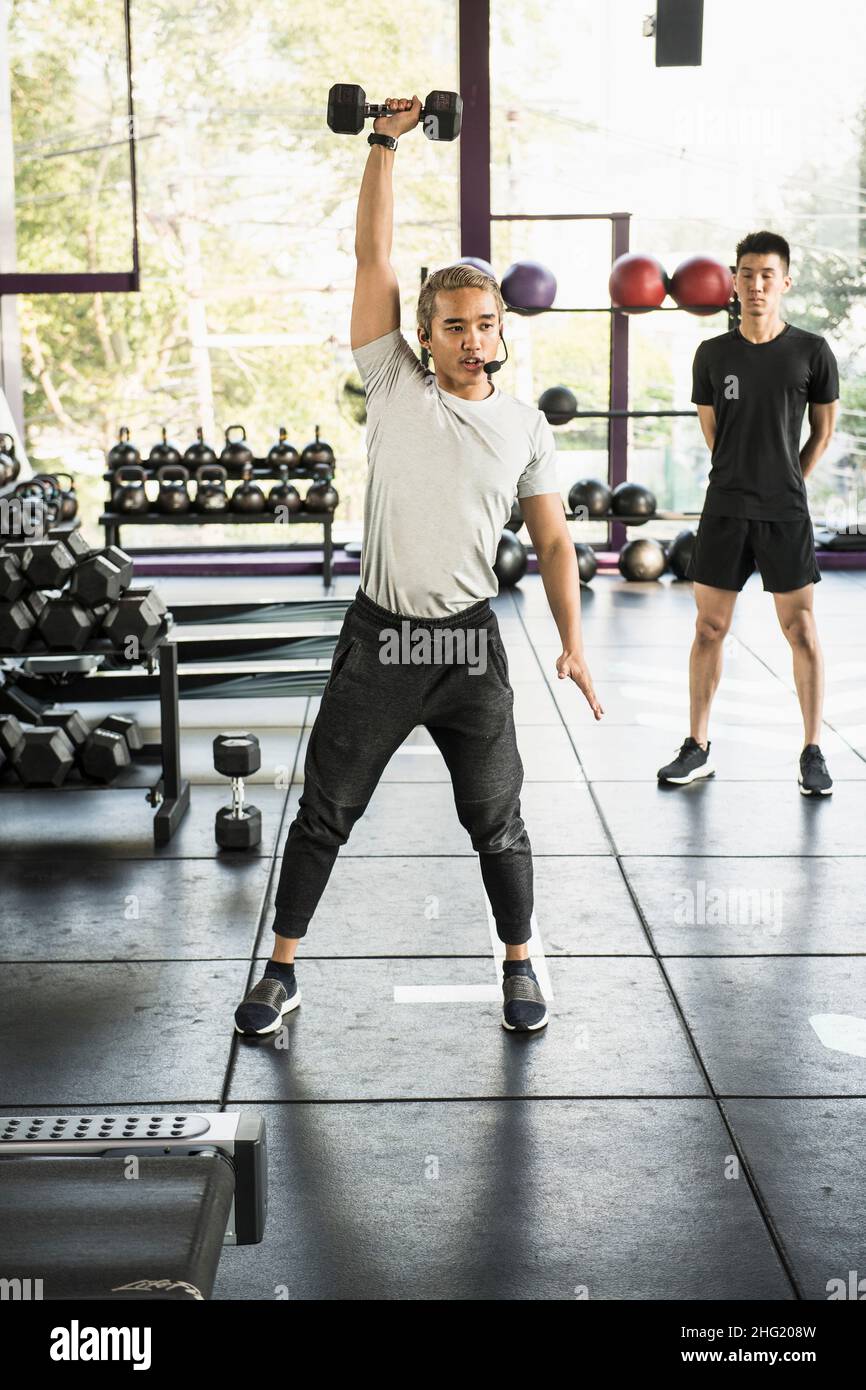 Allenatore che dimostra la testa di stampa durante la lezione in palestra a Bangkok Foto Stock