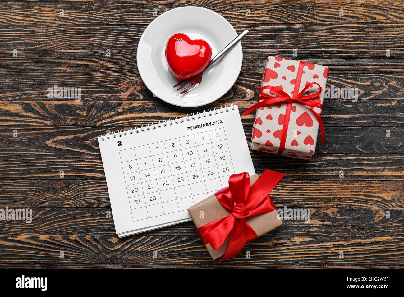 Calendario con scatole regalo e dessert su sfondo di legno scuro. Festa di  San Valentino Foto stock - Alamy