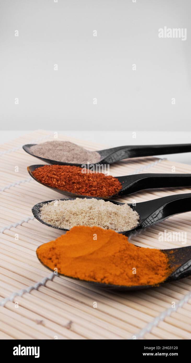 Primo piano le spezie in polvere sui cucchiai Foto Stock