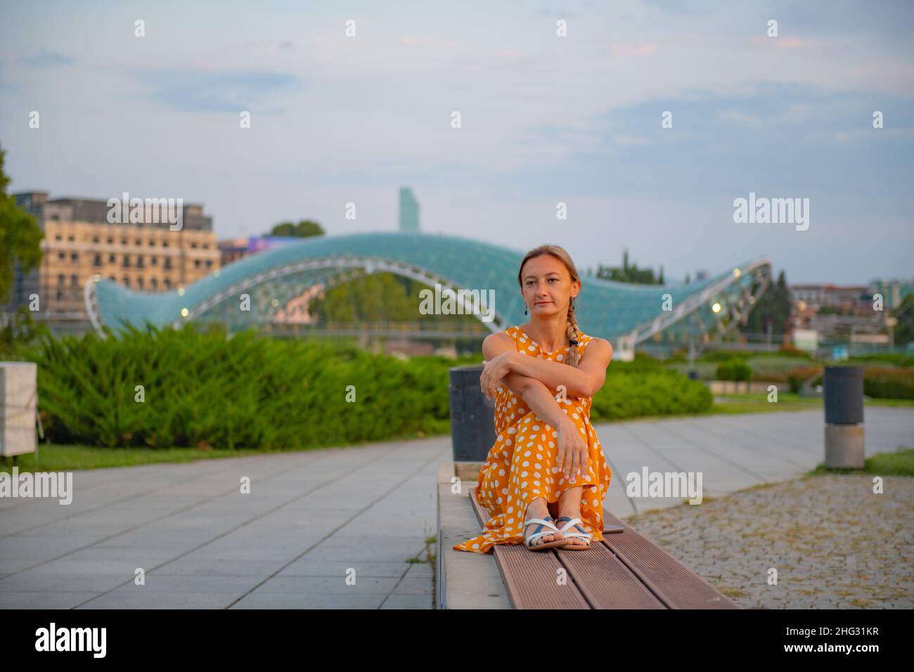 una ragazza seduta su una panchina a tbilisi Foto Stock