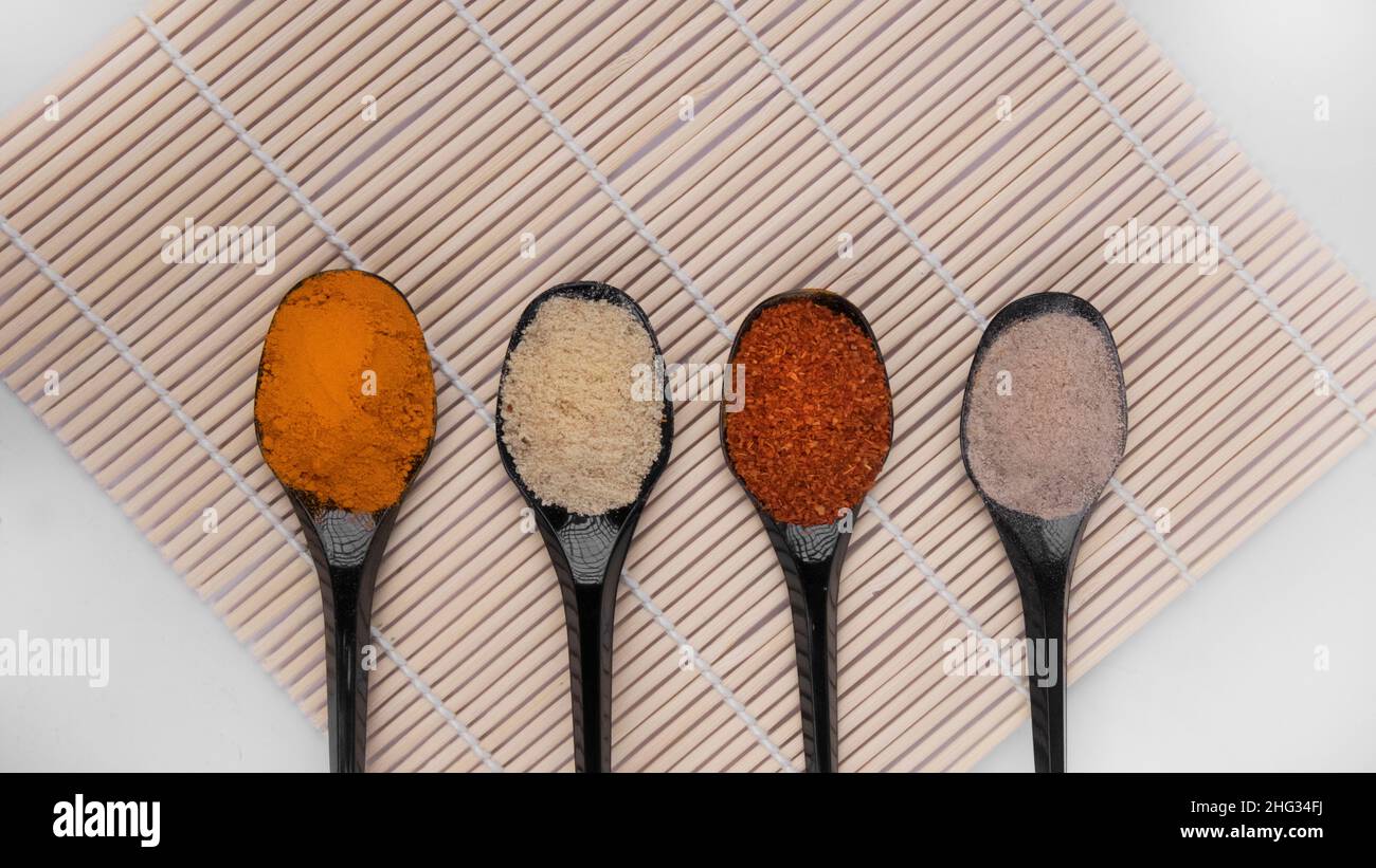 Cucchiaio di spezie in polvere su un mat di bambù Foto Stock