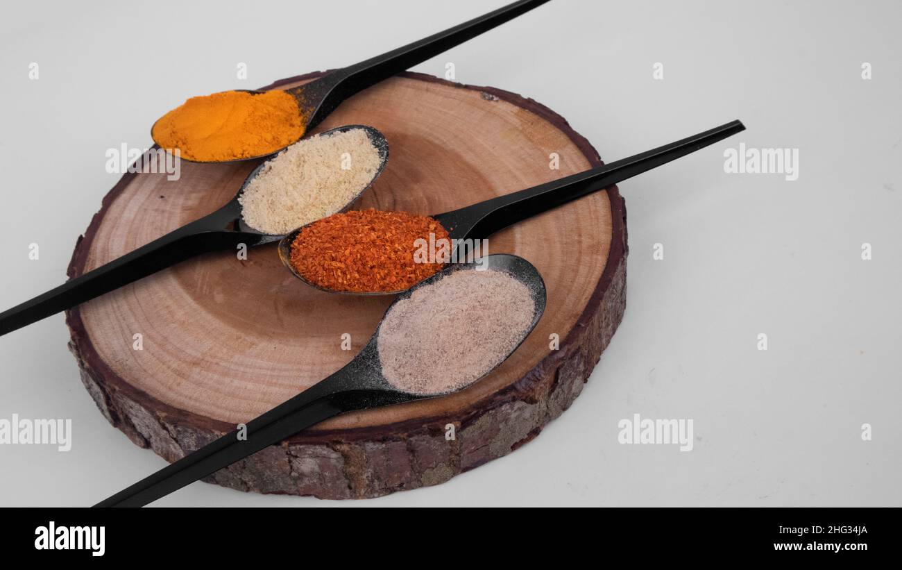 Spoonful Speices in polvere su Coaster di legno Foto Stock