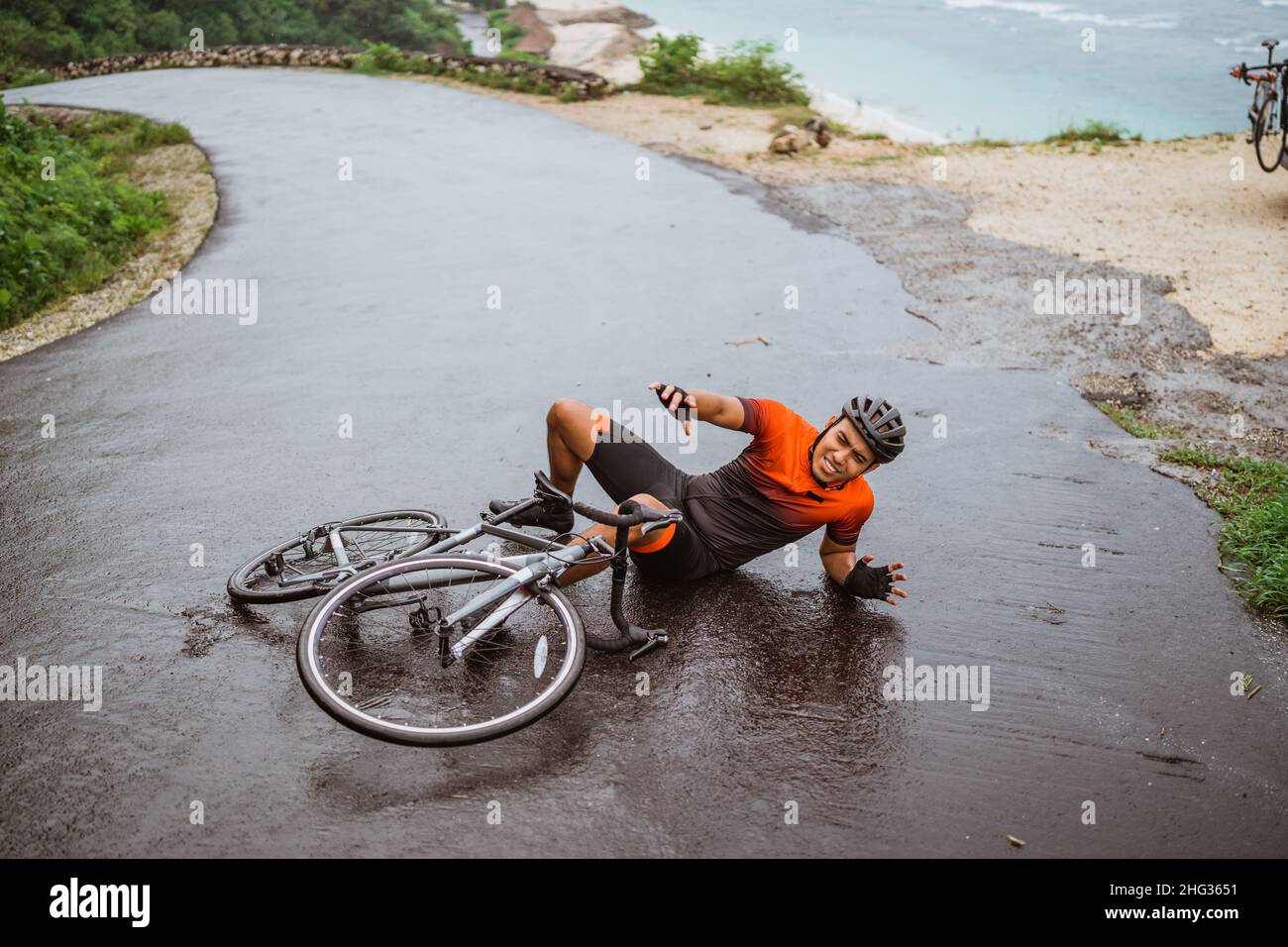 Il ciclista esausto cadde sulla strada Foto Stock