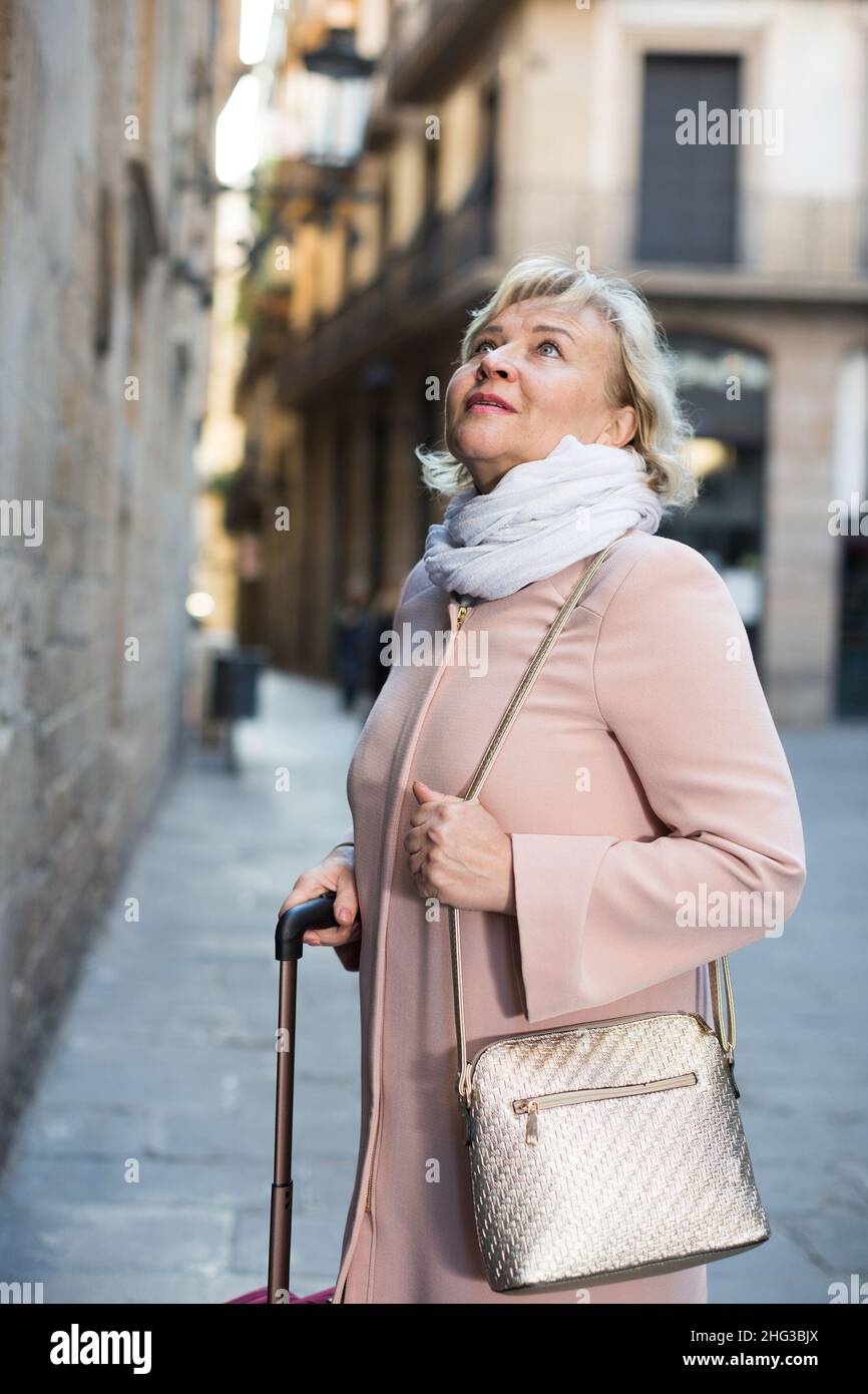 Donna nella città vecchia in sciarpa e cappotto Foto stock - Alamy