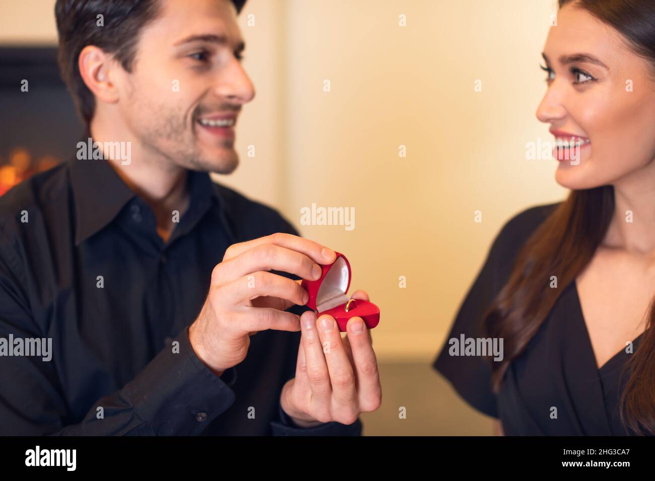 Uomo sorridente che fa proposta con anello alla sua fiance Foto Stock