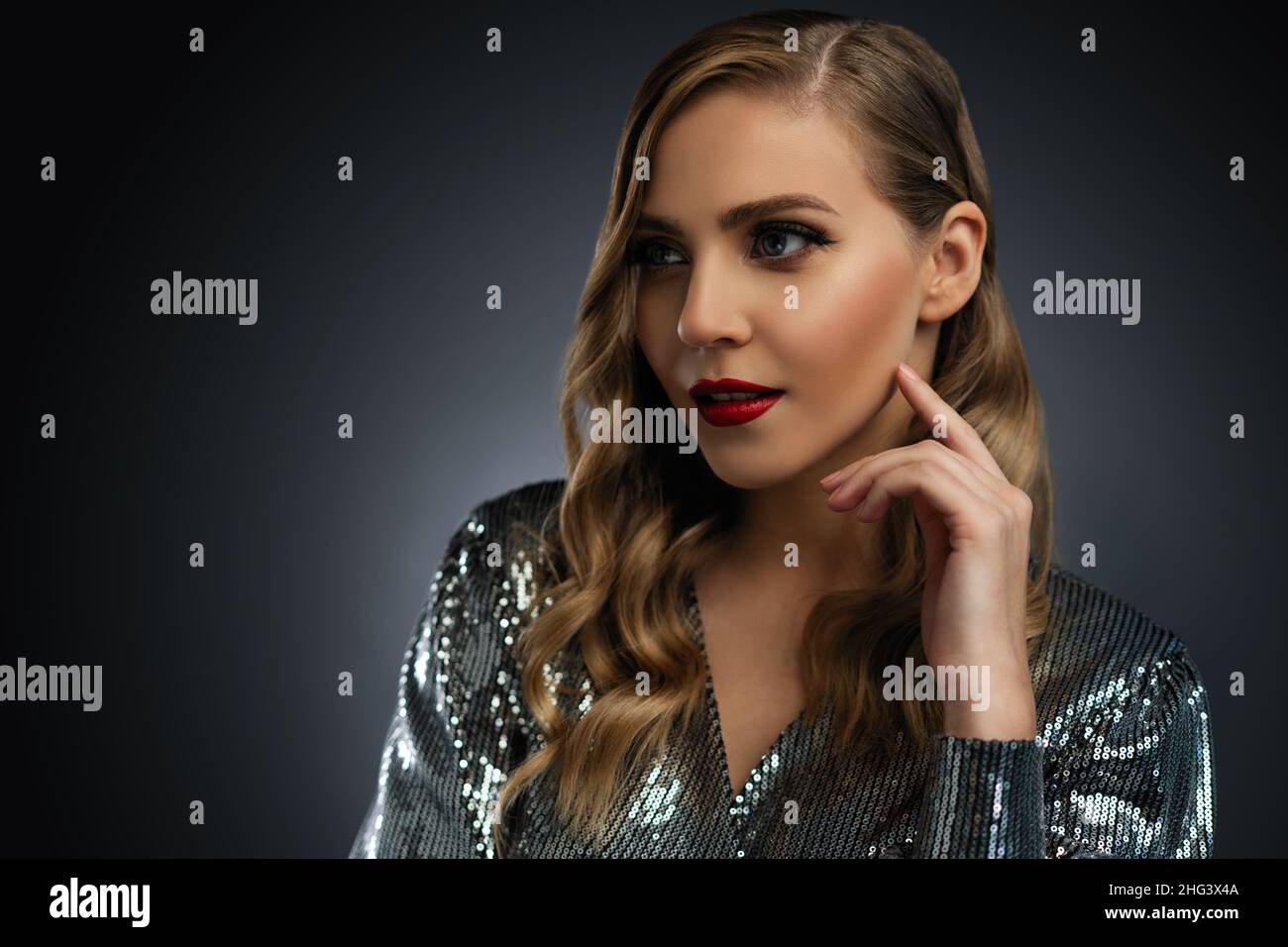 Donna modello di bellezza con capelli lunghi e ondulati. Capelli sani e trucco professionale bello. Labbra rosse e occhi affumicati compongono. Splendida Signora Glamour Portrai Foto Stock