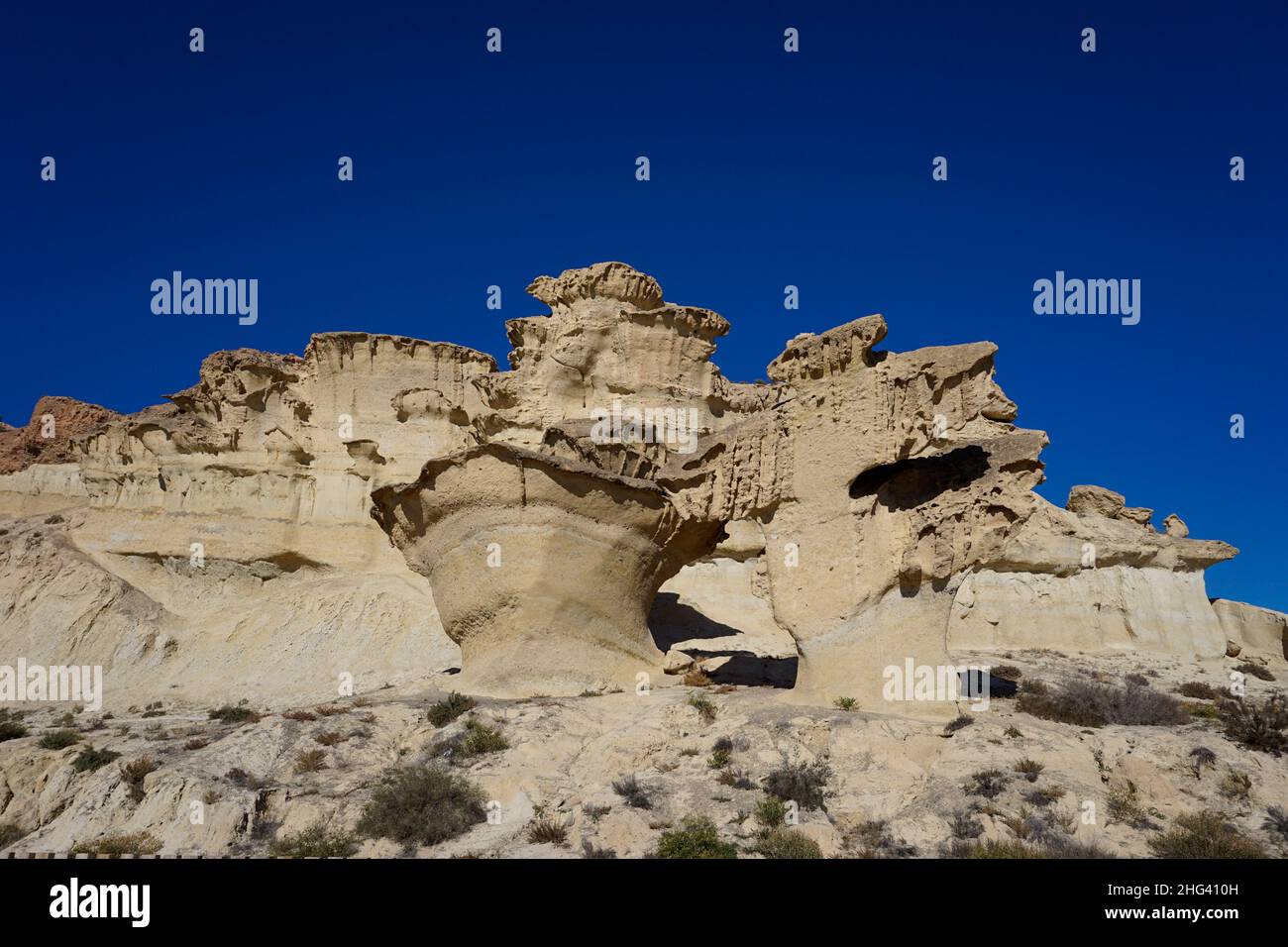 Una vista delle famose erosioni di arenaria e degli hoodoos a Bolnuevo sotto un cielo blu chiaro Foto Stock