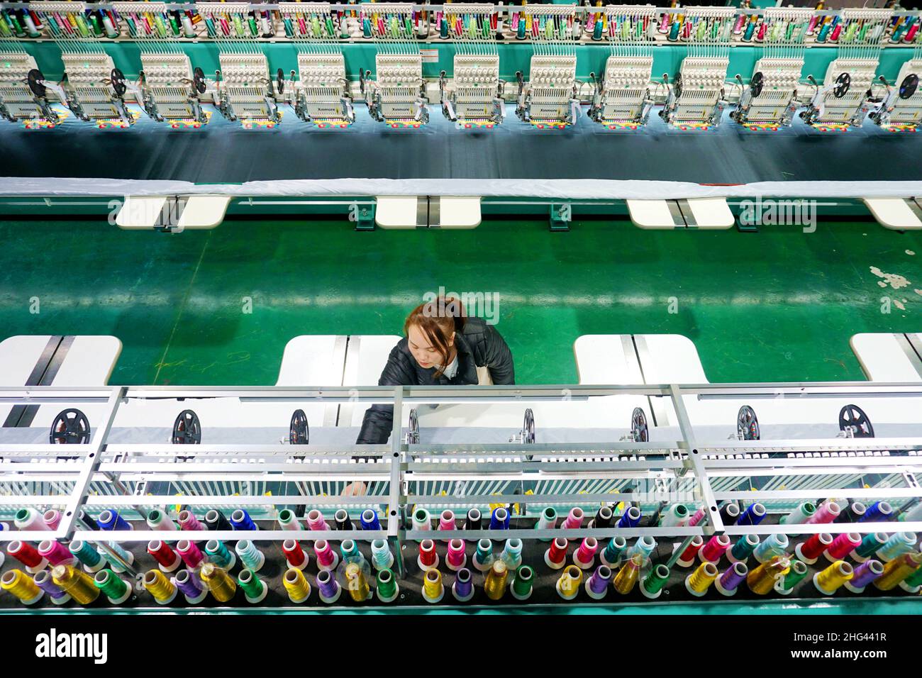 QIANDONGNAN, CINA - 18 GENNAIO 2022 - Una donna locale addestrata lavora su una linea di produzione di cucito di poliestere a Qiandongnan, Guizhou Pr della Cina sudoccidentale Foto Stock
