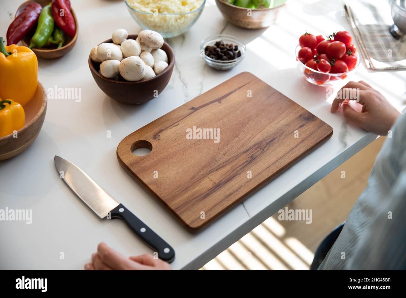 Nella vera cucina, il tagliere e il coltello sono affiancati sul bancone. Verdure al banco. Chef. Foto Stock
