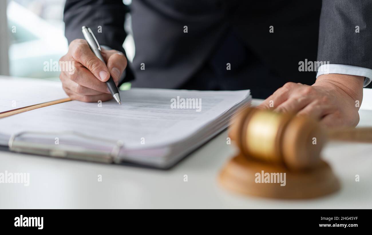 concetto di legge il funzionario legale è in piedi e si concentra sulla lettura delle condizioni legislative prima di firmare il documento. Foto Stock