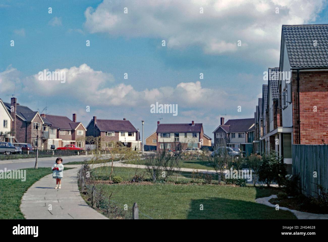 Nuovo alloggio in un cul-de-sac a Crawley ‘New Town’, West Sussex, Inghilterra, Regno Unito nel 1966. Questo sviluppo privato con case in vendita era una caratteristica meno comune nei 14 sobborghi sviluppati per creare la 'nuova città' del dopoguerra. La maggior parte delle case e degli appartamenti sono stati finanziati con fondi pubblici. Dopo la seconda guerra mondiale, al fine di delocalizzare coloro che vivono nelle abitazioni povere o bombardate di Londra, un gran numero di persone e di posti di lavoro sono stati spostati in nuove città intorno alla se Inghilterra e Crawley è stata la prima di queste – una fotografia d’epoca del 1960s. Foto Stock