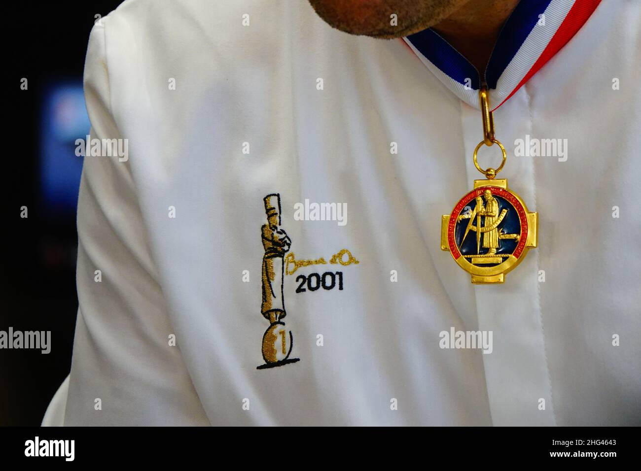 Primo piano della medaglia d'oro e uniforme di uno chef vincitore del premio Paul Bocuse, a Lione, Francia Foto Stock