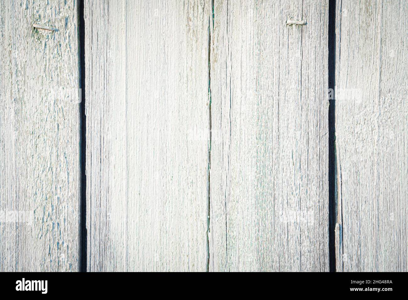 Sfondo bianco-grigio invecchiato in legno con una texture pronunciata. Vecchie tavole bianche dipinte. Foto Stock