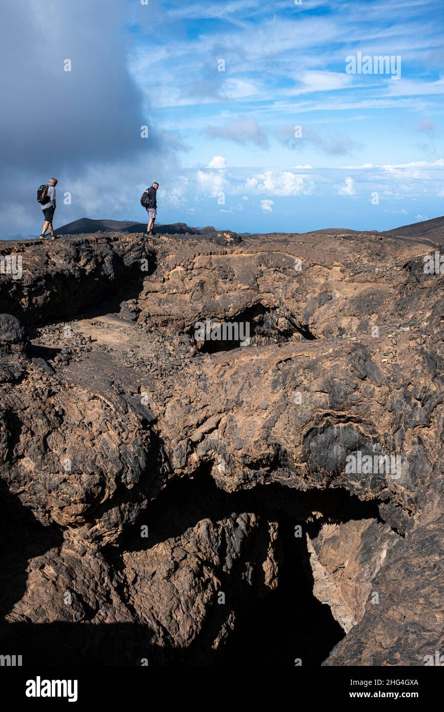 Due uomini che camminano per i tubi di lava di Cuevas Negras, grotte, nella zona montana di Samara del Parco Nazionale Las Cañadas del Teide, Tenerife, Canary Islan Foto Stock