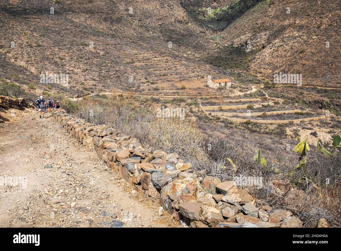 Gruppo di escursionisti su una pista accidentata passando una vecchia finca abbandonata, fattoria a San Miguel de Abona, Tenerife, Isole Canarie, Spagna Foto Stock