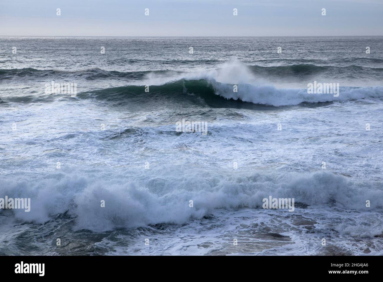 Le onde arrivano dalle campate atlantiche alla spiaggia di Chapel Porth sulla costa settentrionale della Cornovaglia Foto Stock