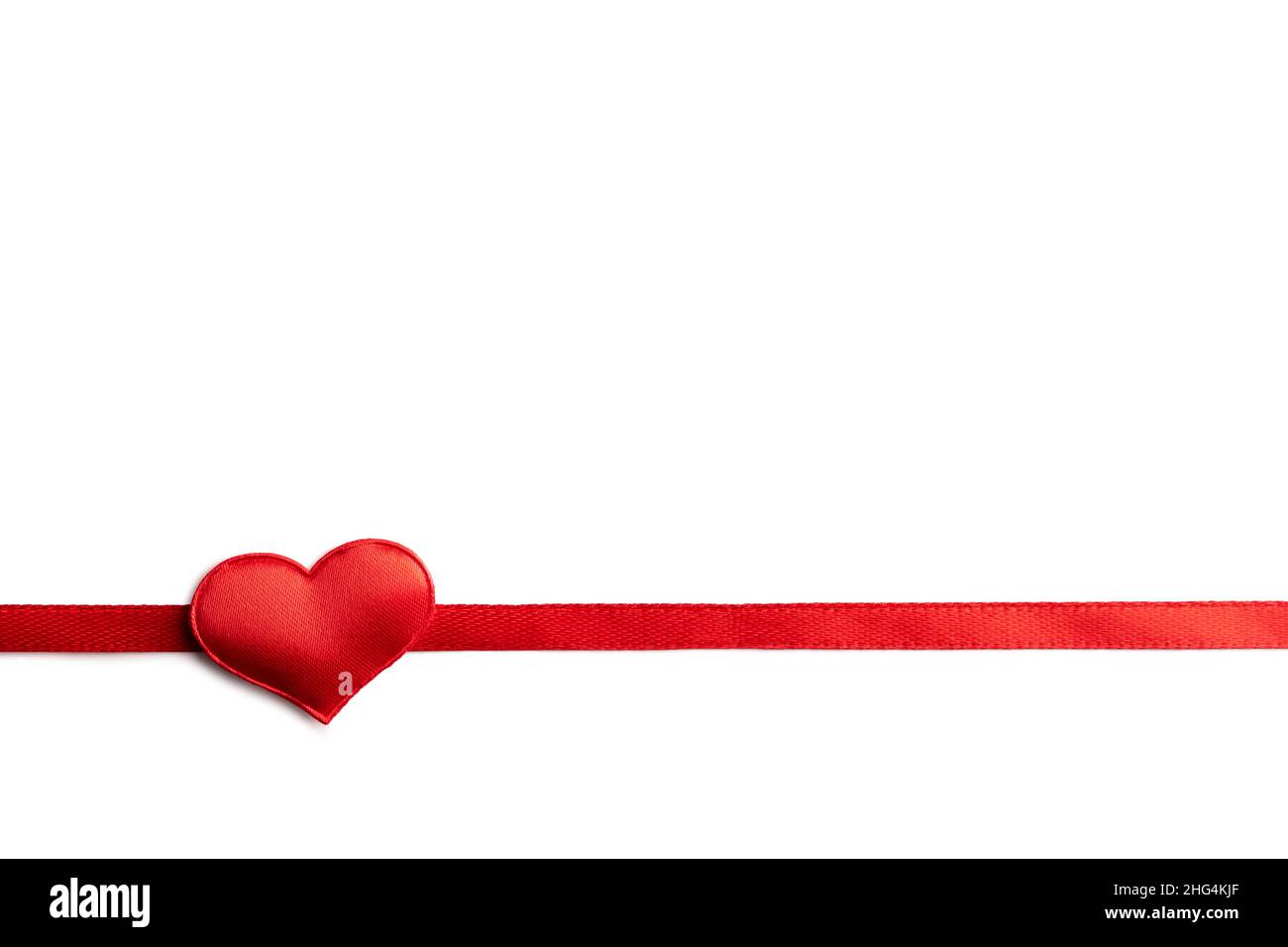 Design da cartolina Creative Valentines Day con nastro rosso e cuore tessile rosso su sfondo bianco isolato. San Valentino e concetto di amore Foto Stock