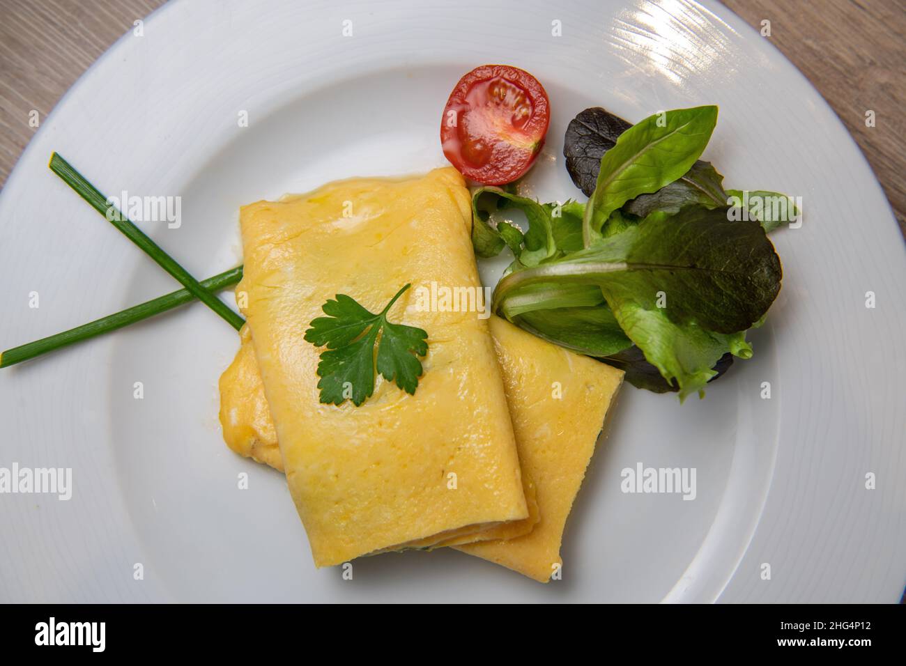 Omelette alle erbe con pomodoro, insalata e prezzemolo, colazione Foto Stock